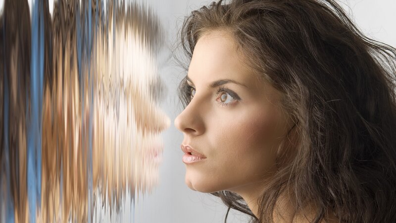 woman looking at distorted reflection