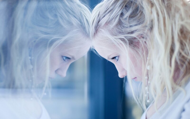 woman looking at her reflection