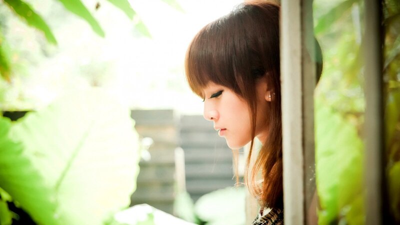 woman looking down by window