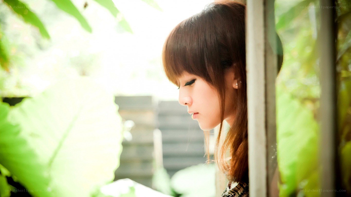 woman looking down by window