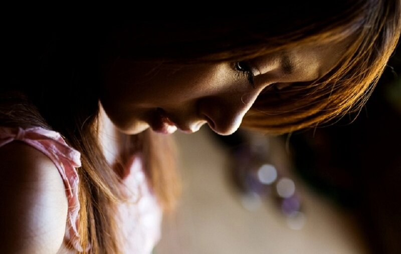 woman looking down in dim light