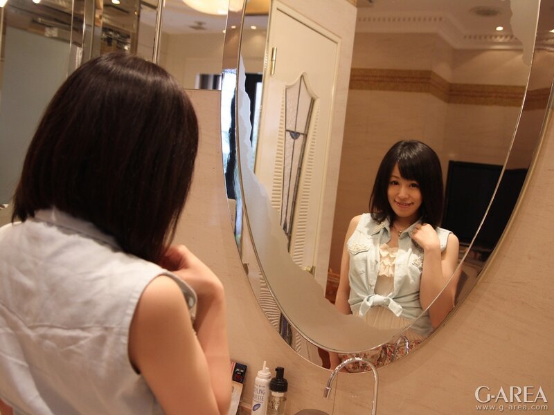 Woman looking in bathroom mirror