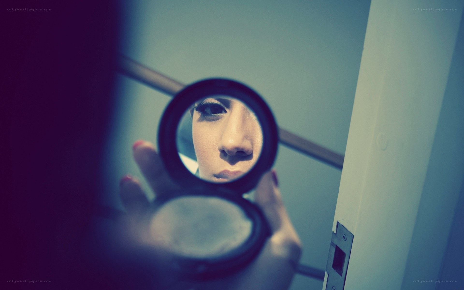 woman looking in compact mirror