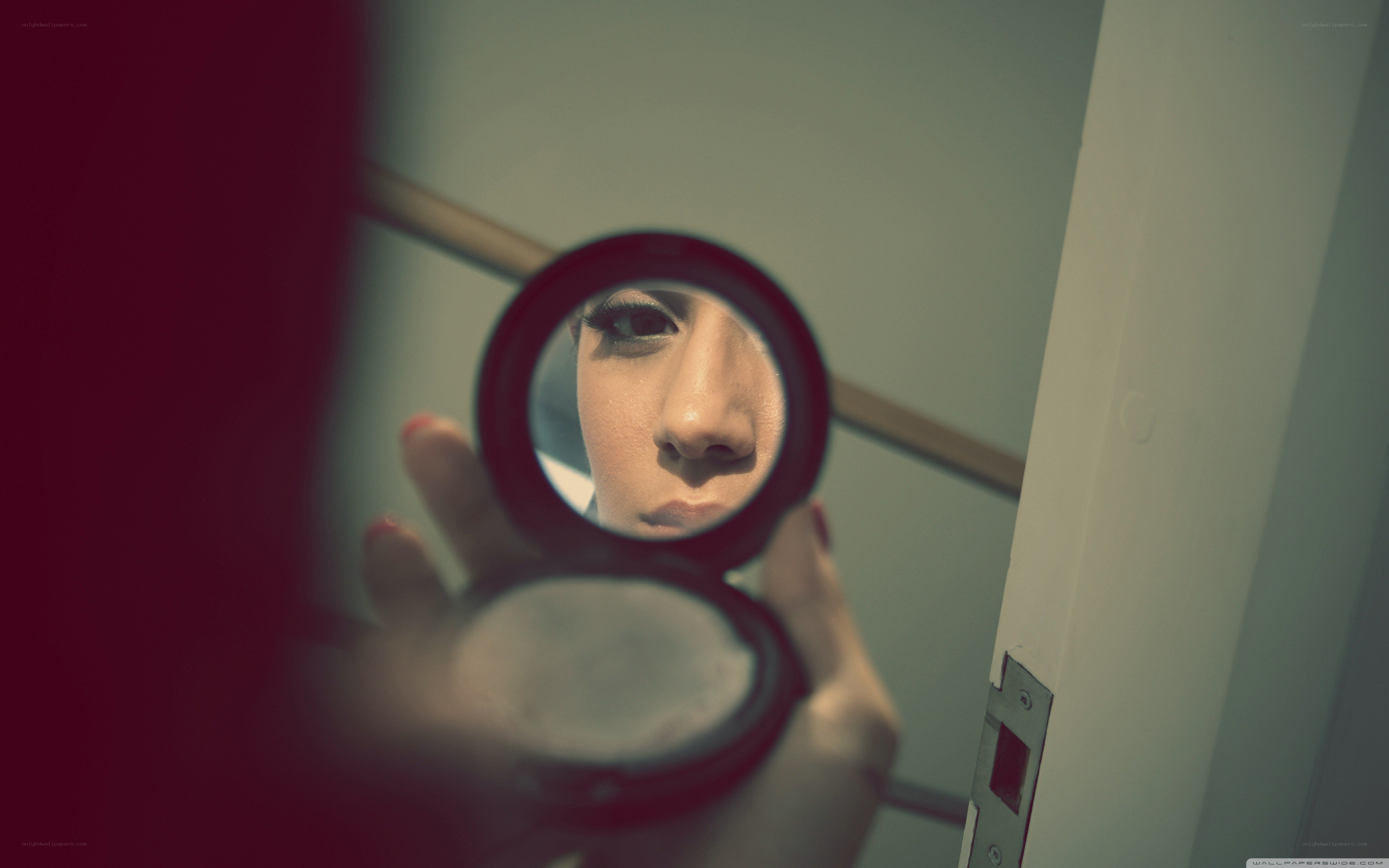 woman looking in compact mirror