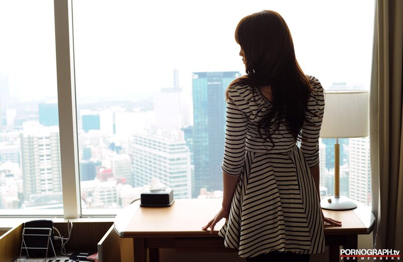 woman looking out city window