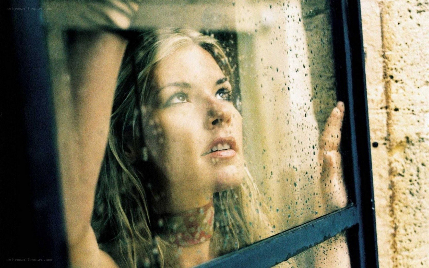 woman looking out rainy window