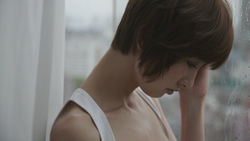 woman looking out rainy window