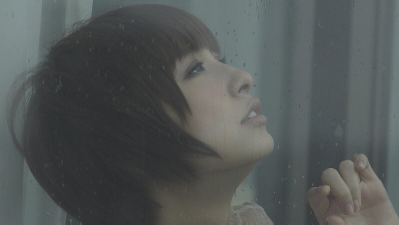 woman looking out rainy window