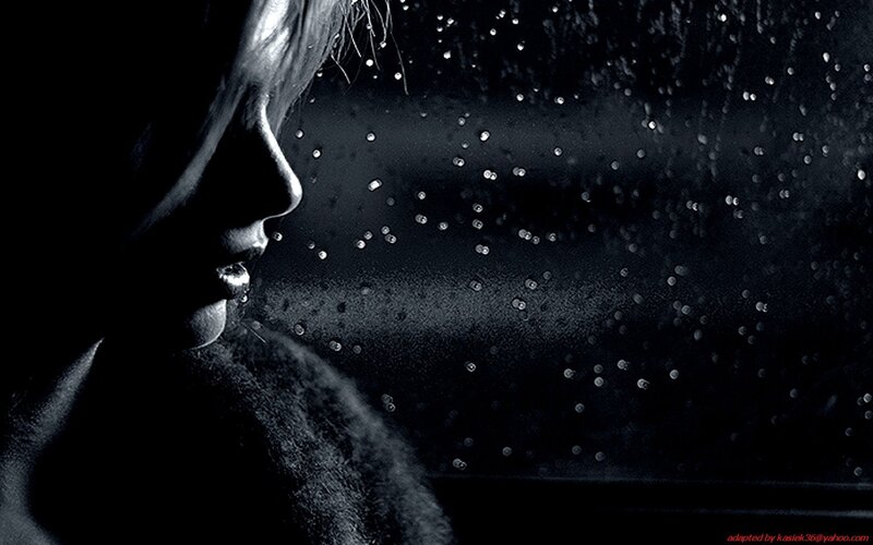woman looking out rainy window