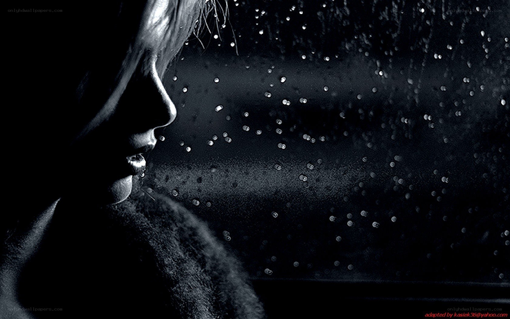 woman looking out rainy window