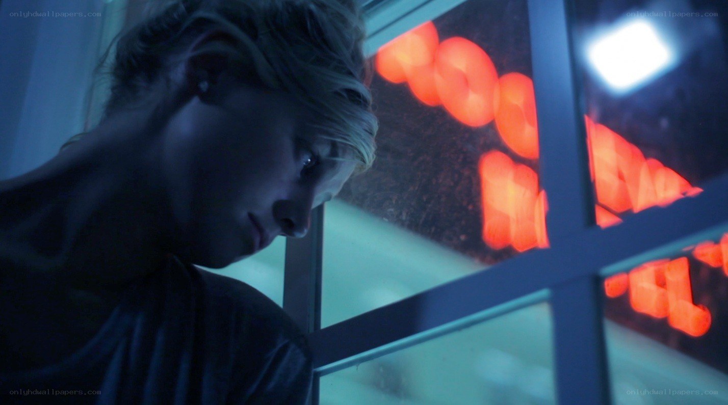 woman looking out window at night