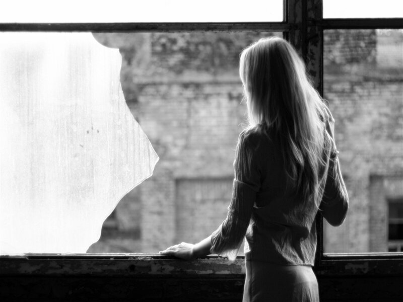 Woman Looking Out Window — Black, Melancholic, Photograph, Brick Wall