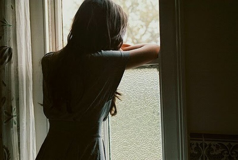 Woman Looking Out Window — Gray