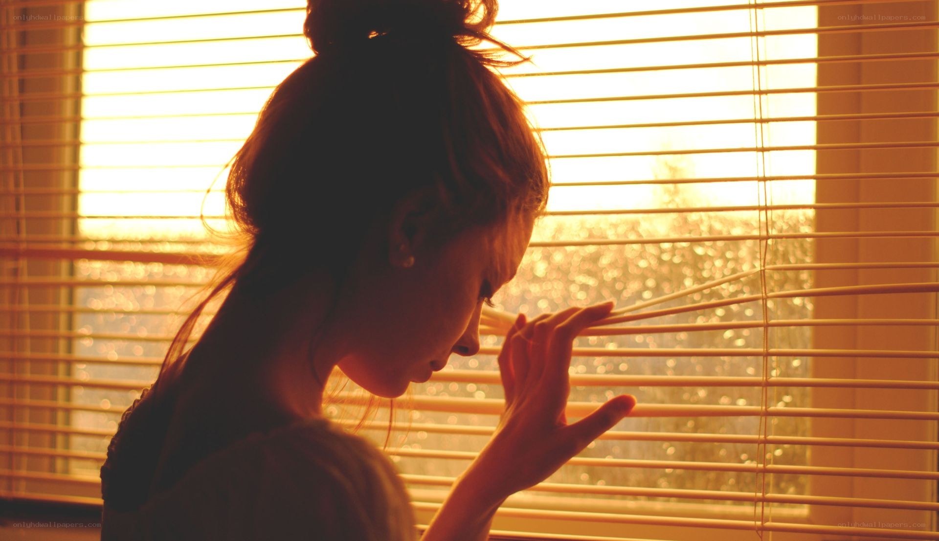 woman looking through blinds