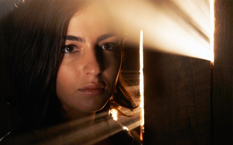 Woman Looking Through Blinds — Brown