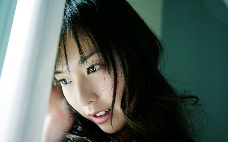 woman looking through curtain