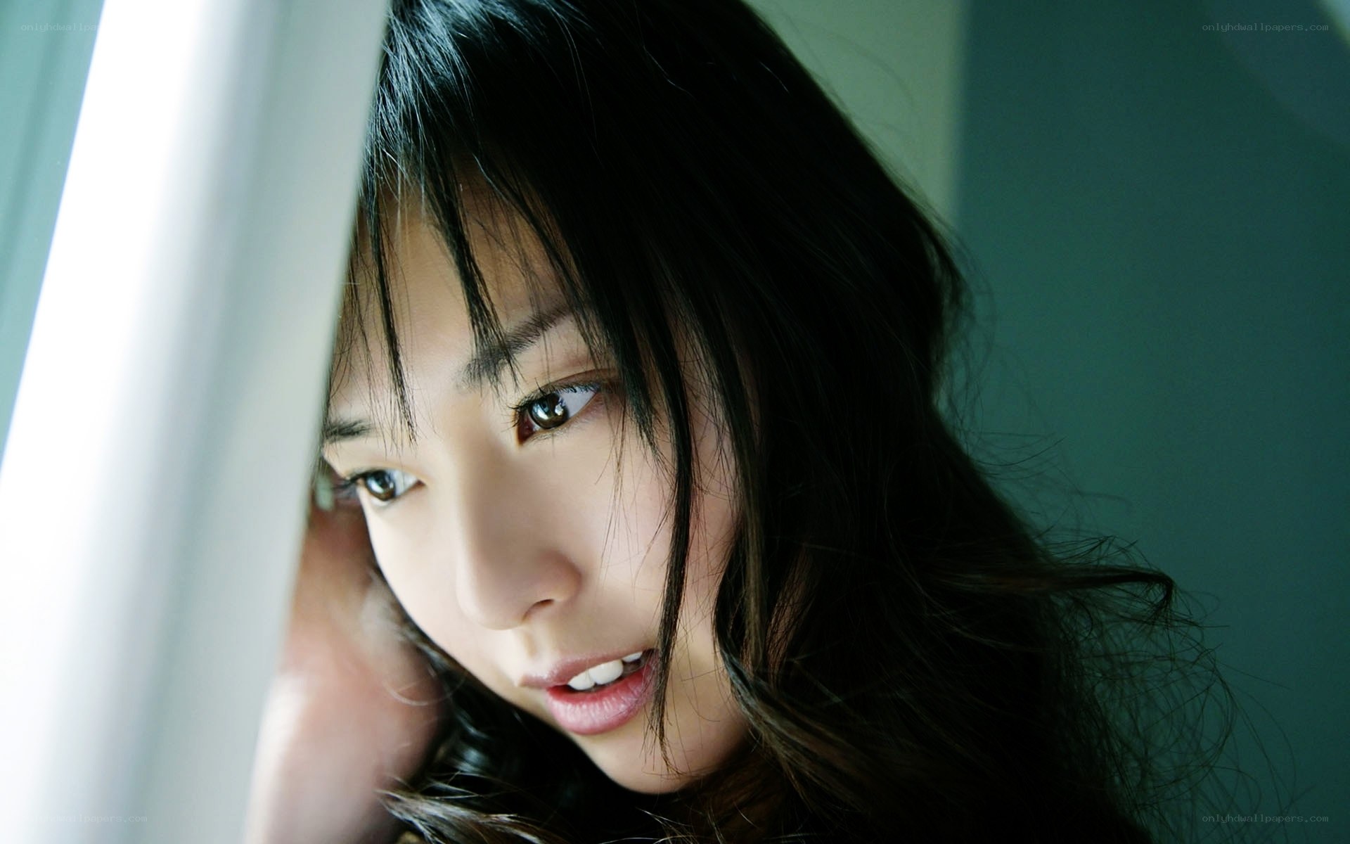 woman looking through curtain