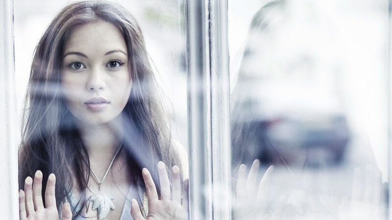 woman looking through glass window
