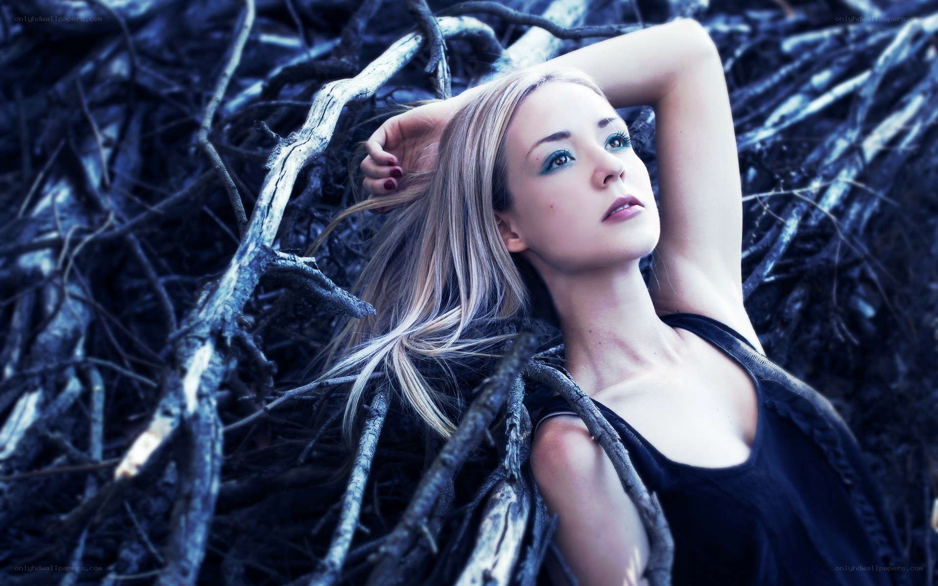 woman lying among branches