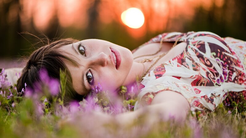 woman lying in a field at sunset