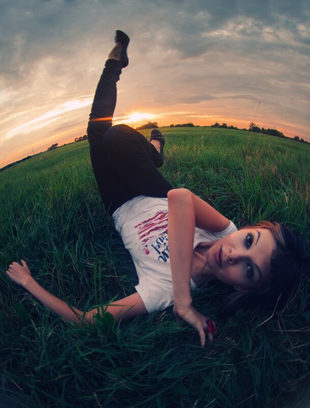 woman lying in a field at sunset