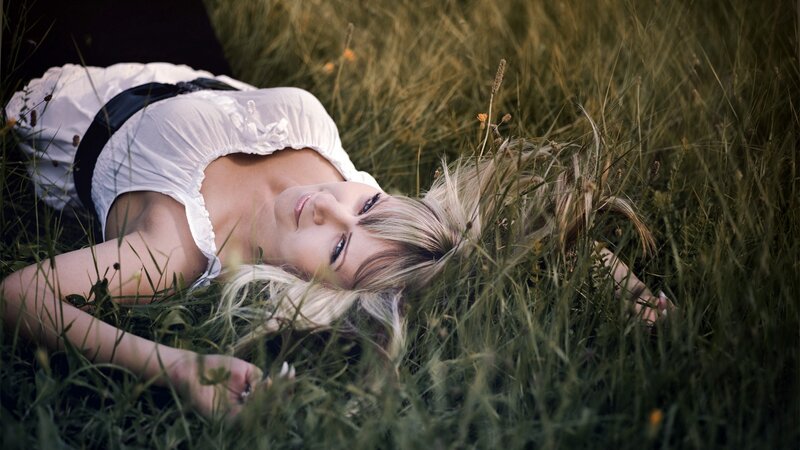 Woman lying in a grassy field