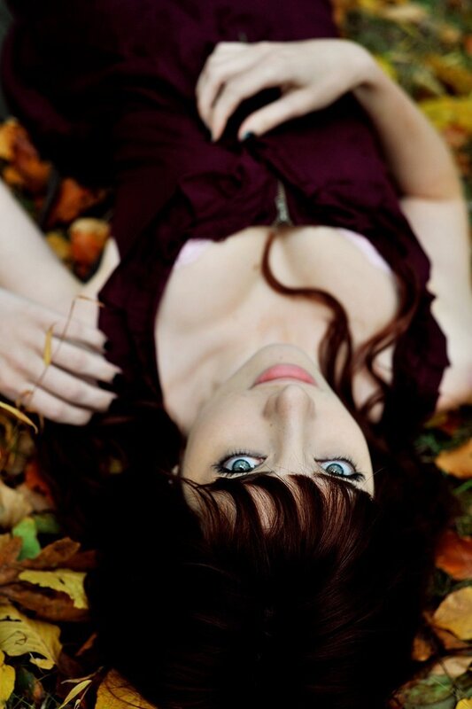 woman lying in autumn leaves
