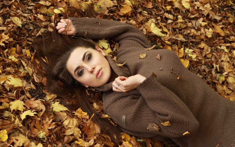 woman lying in autumn leaves
