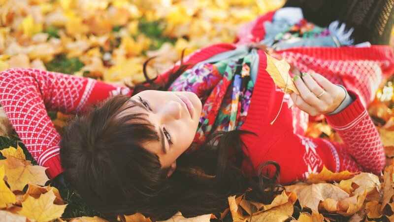 woman lying in autumn leaves