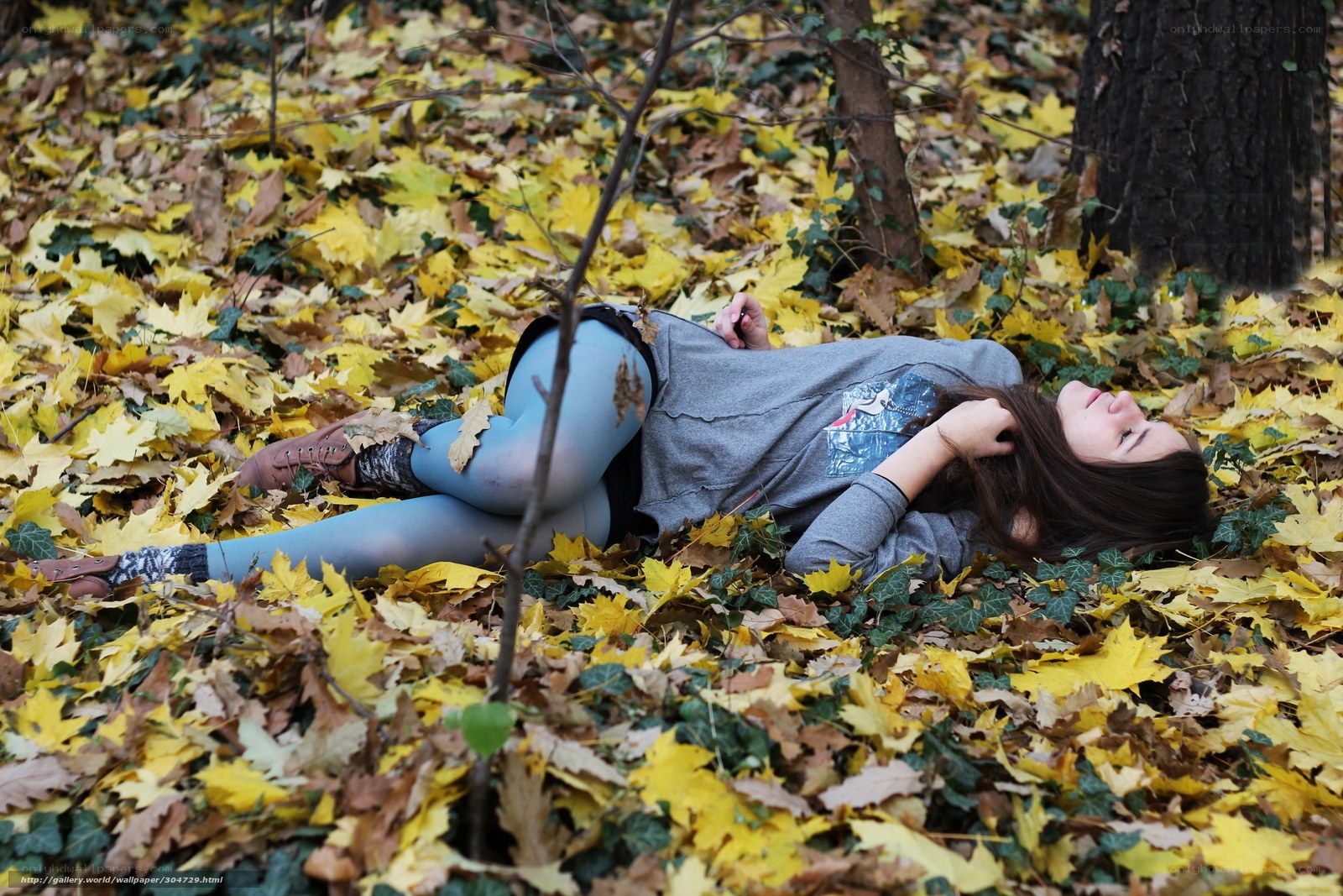 woman lying in autumn leaves