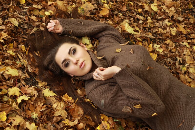 woman lying in autumn leaves