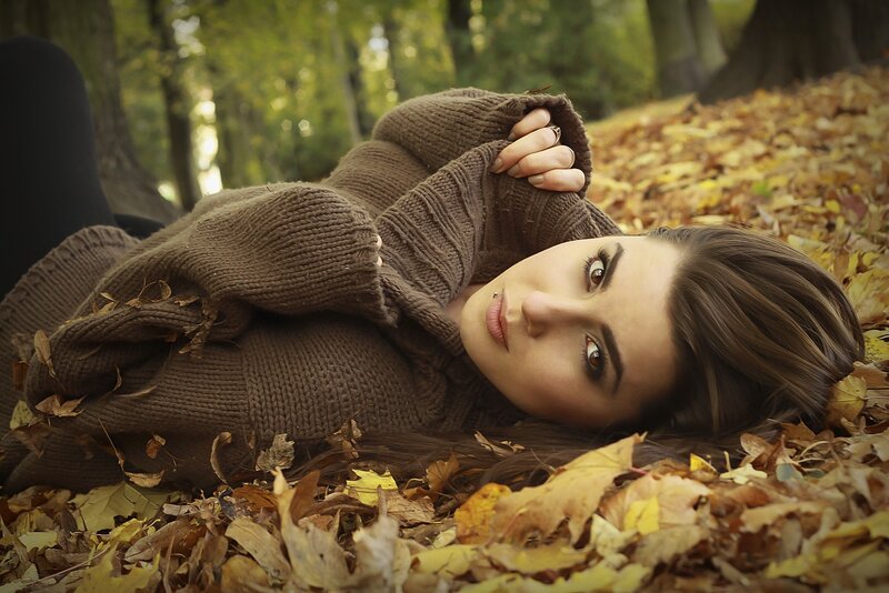 woman lying in autumn leaves