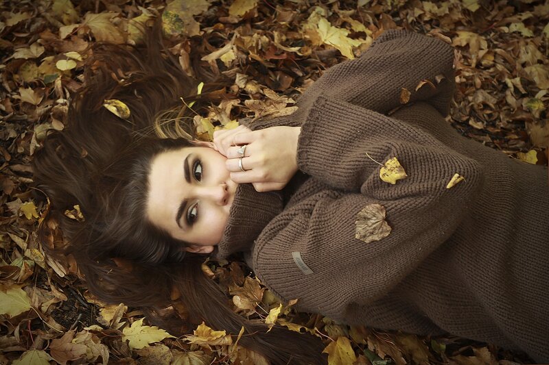 woman lying in autumn leaves