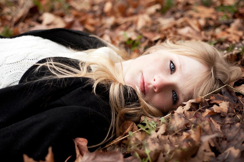 woman lying in autumn leaves