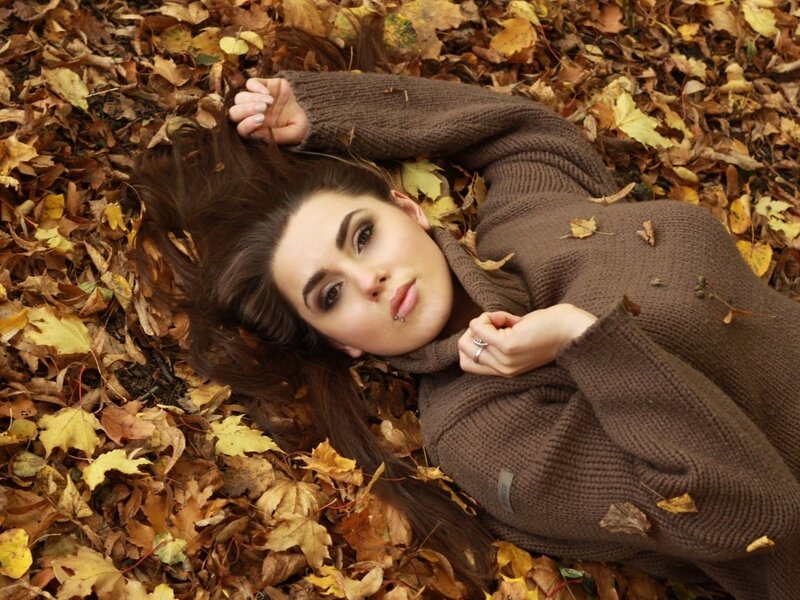 woman lying in autumn leaves