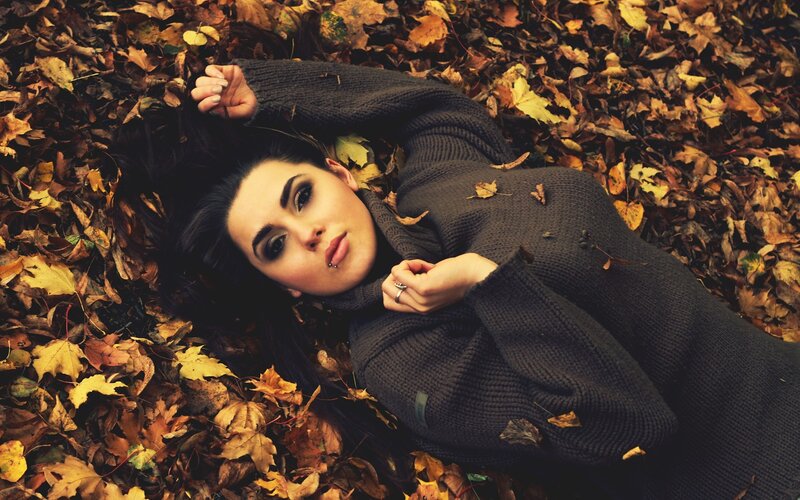 woman lying in autumn leaves