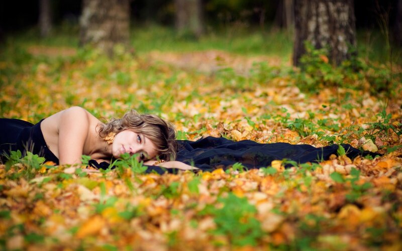 woman lying in autumn leaves