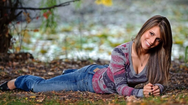 woman lying in autumn leaves
