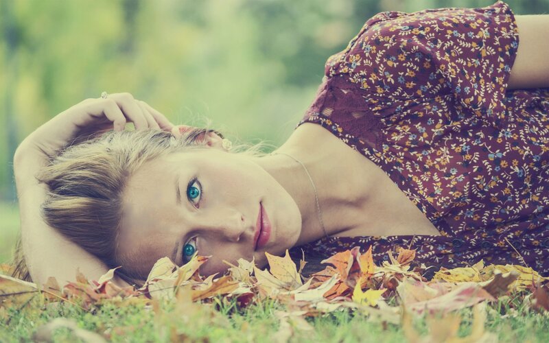 woman lying in autumn leaves