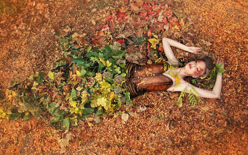 woman lying in autumn leaves