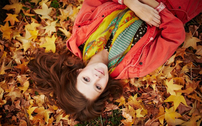 woman lying in autumn leaves