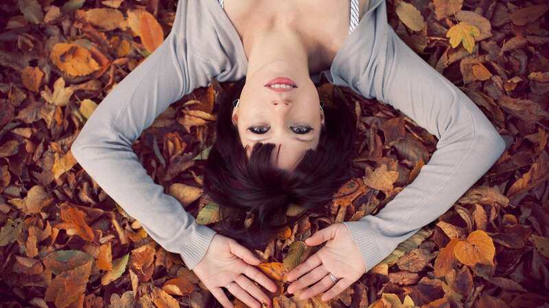 woman lying in autumn leaves