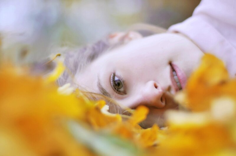 woman lying in autumn leaves