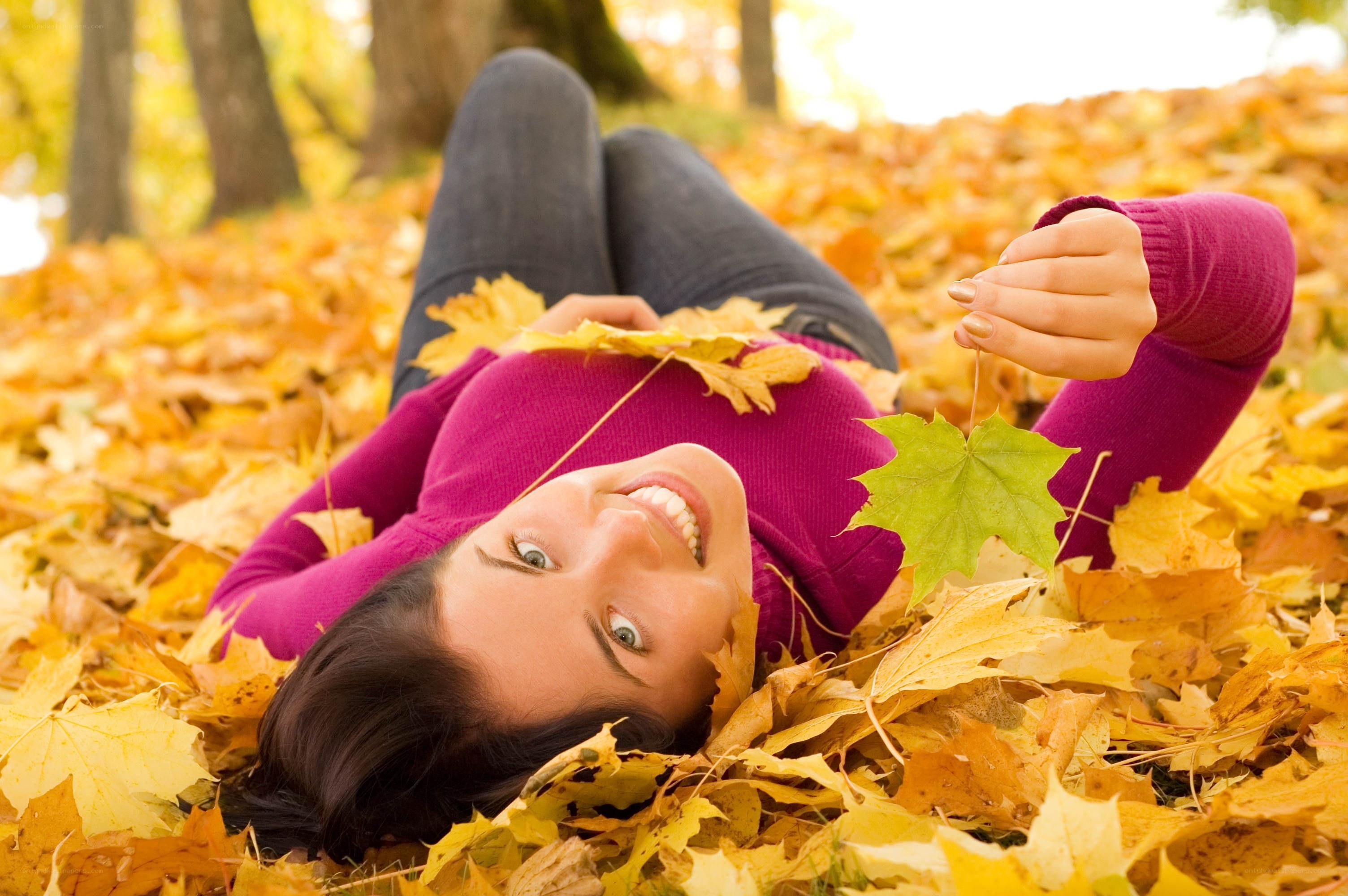Woman lying in autumn leaves