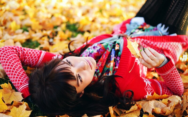woman lying in autumn leaves
