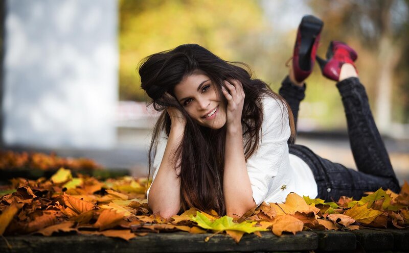 woman lying in autumn leaves