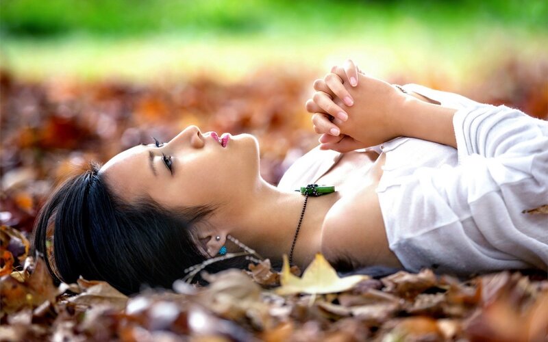 woman lying in autumn leaves