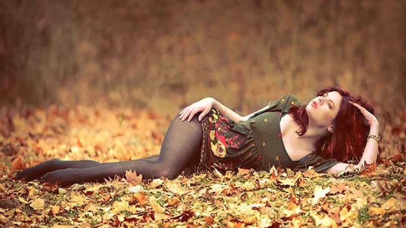 woman lying in autumn leaves