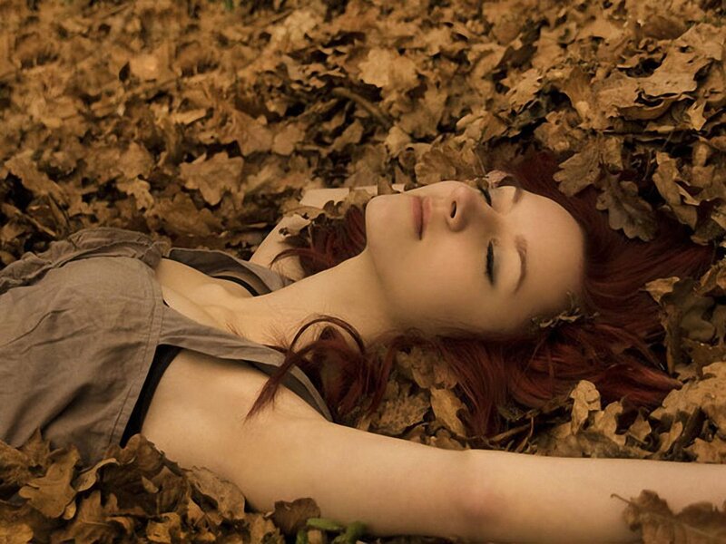 woman lying in autumn leaves