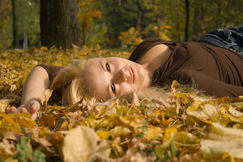 woman lying in autumn leaves